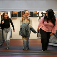 Three students walking up stairs in a high school