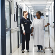 A nurse and patient walking through a hospital hallway