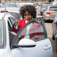A woman stepping out of her parked vehicle