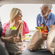 An older couple putting groceries into their vehicle